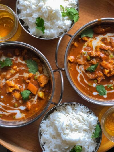Bowls of Indian curry with rice and cilantro